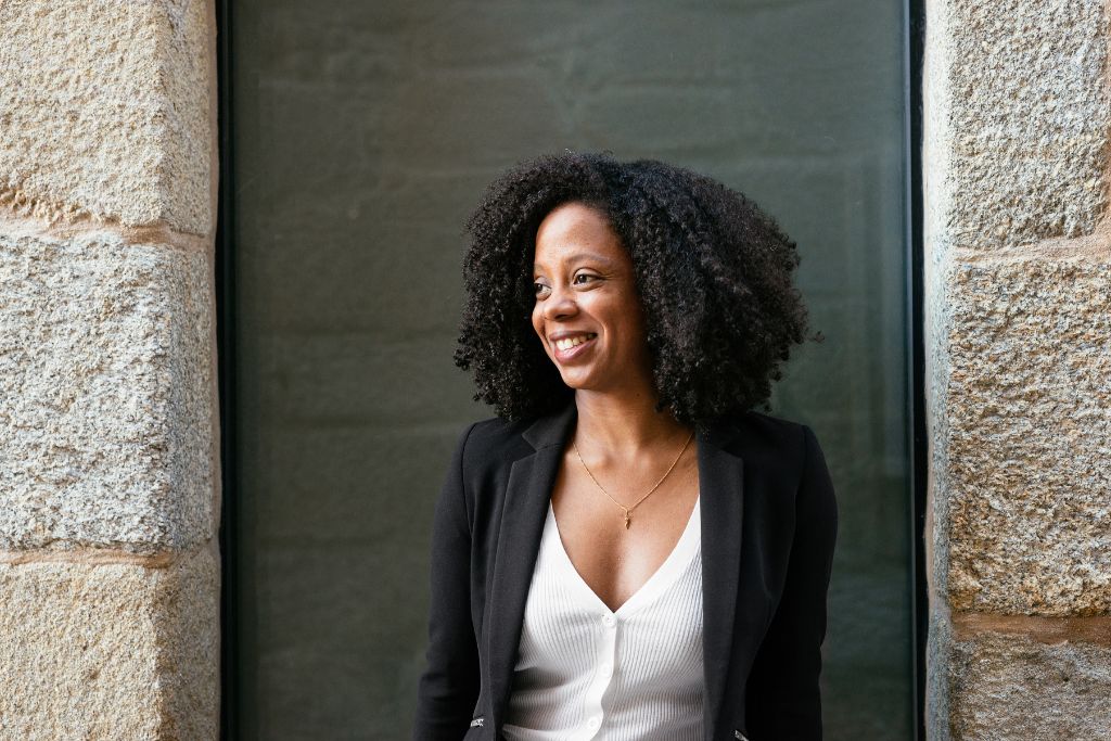 Confident woman standing outside a building, representing progress through therapy