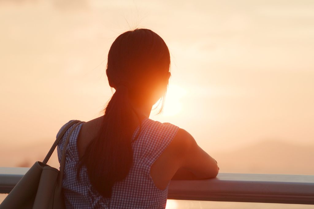 Woman gazing at the sunset, symbolising reflection and hope after loss