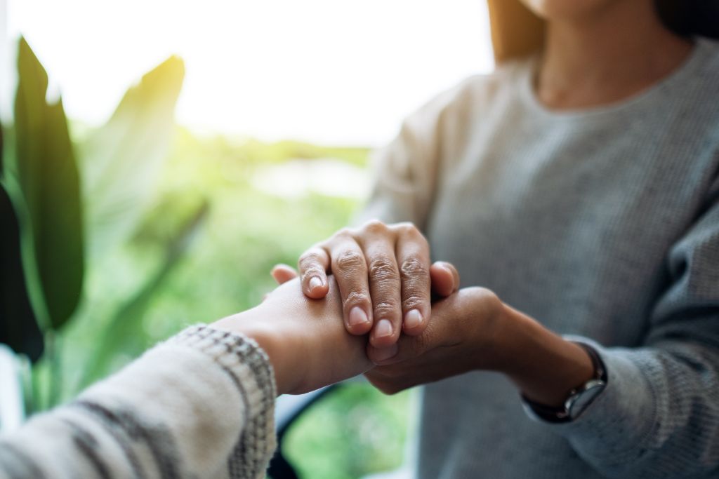 Close-up of hands offering support and comfort