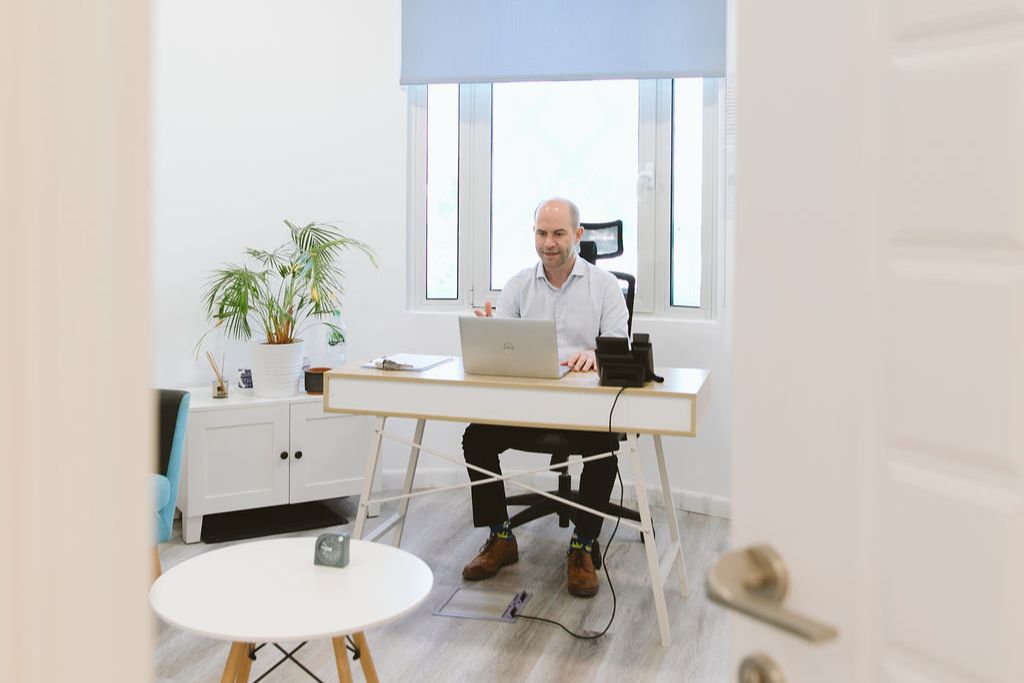 Male therapist at Vivamus conducting an online therapy session from his office