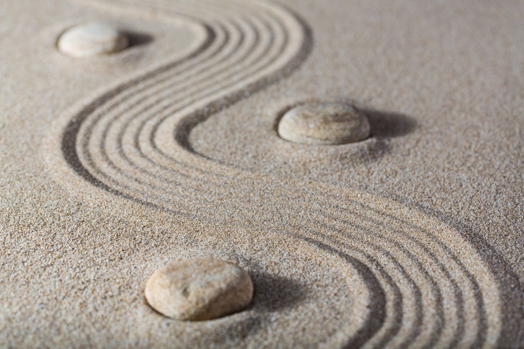 A smooth sand pattern with balanced stones, symbolising clarity and positive change