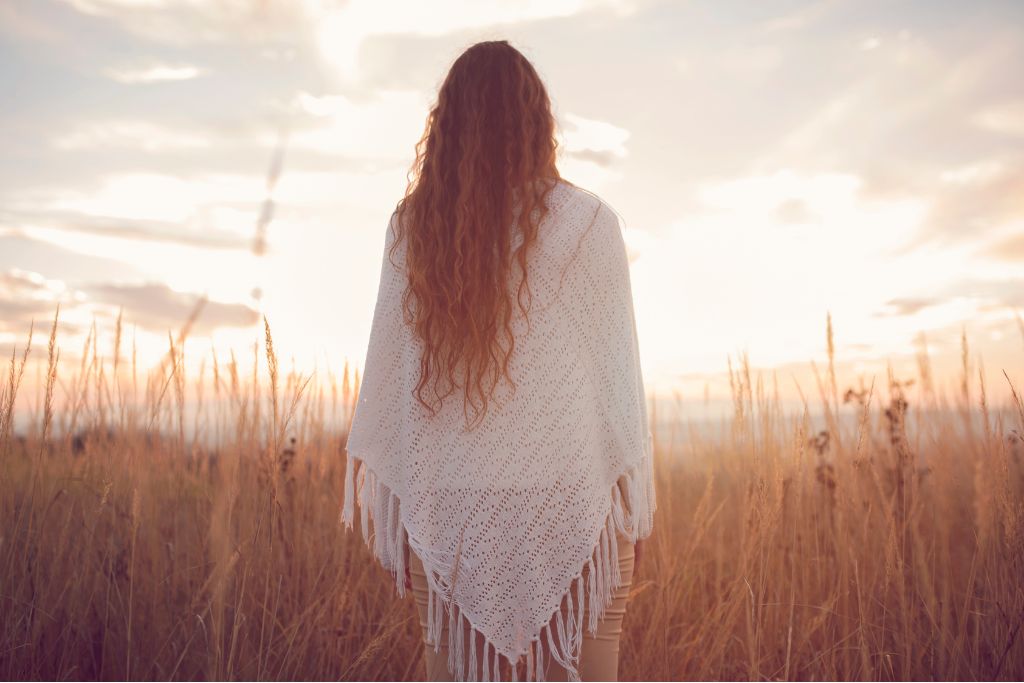 Person standing in open field at sunrise reflecting hope and clarity