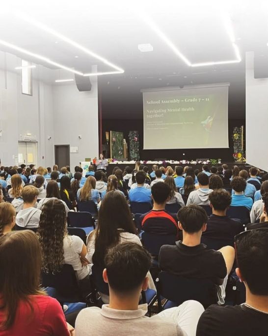 School assembly with students attending a mental health and wellbeing presentation