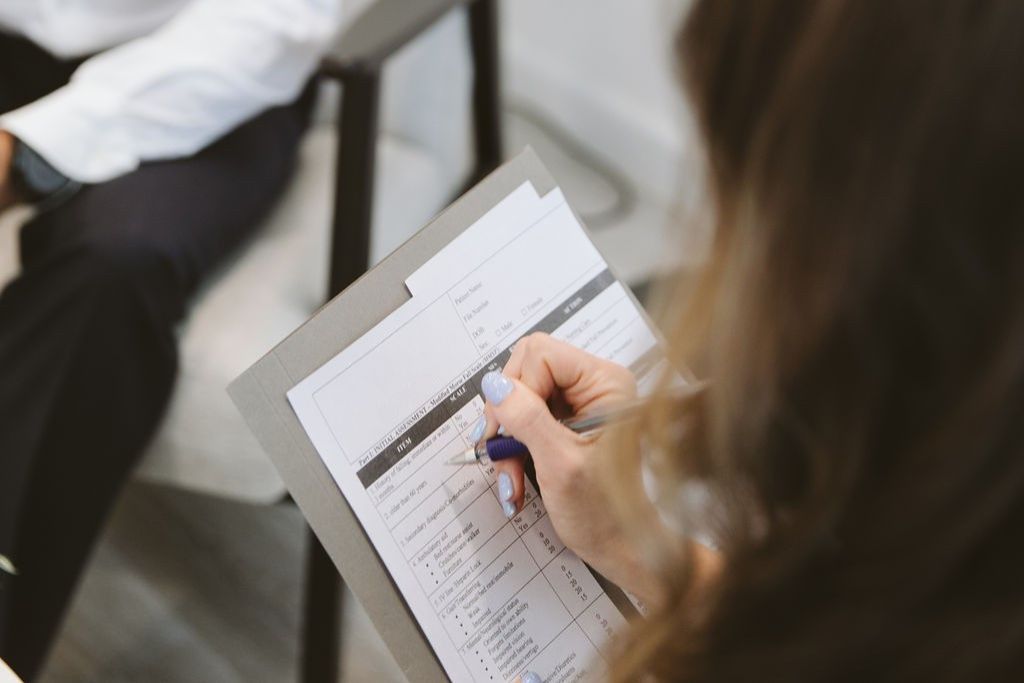 Psychologist in Dubai completing an assessment form during a client session at Vivamus