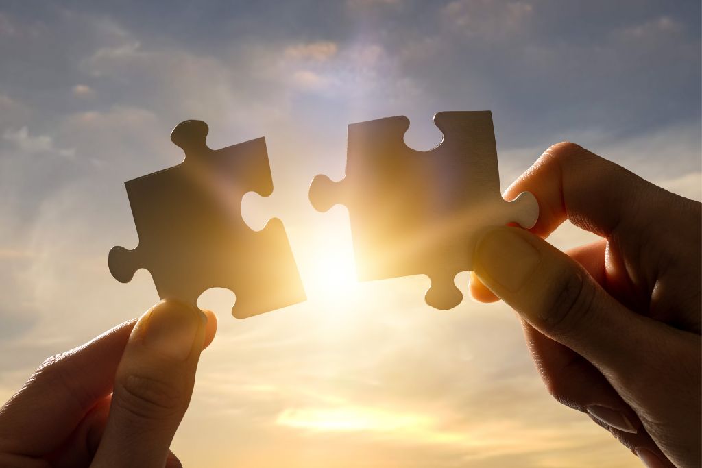 Two hands holding puzzle pieces to symbolise finding the missing piece through psychological assessment and therapy
