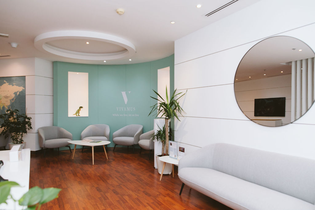 Vivamus clinic waiting area with soft seating, wood floors, and a calming mint green feature wall
