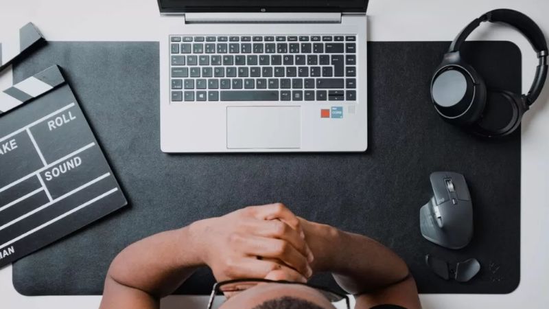 Man with hands behind head at a desk representing workplace stress and burnout