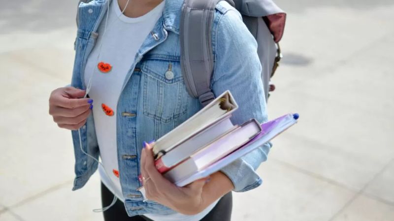 Student holding books and backpack symbolising academic transition support